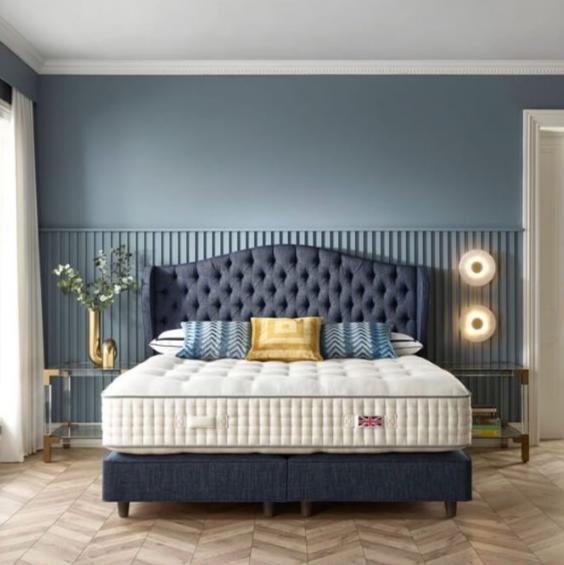 Harrison Spinks Leicester mattress in a styled room with a blue headboard and base.